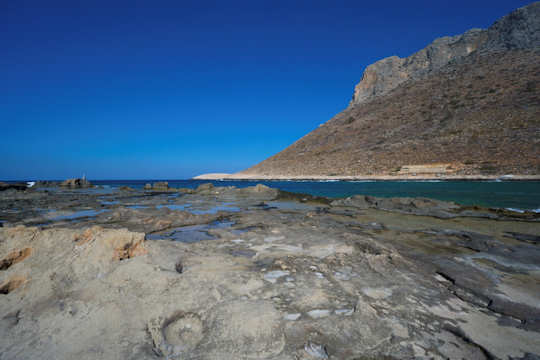 The rock pools of Stavros Beach, looking over the bay to Stavros or Vardies Mountain